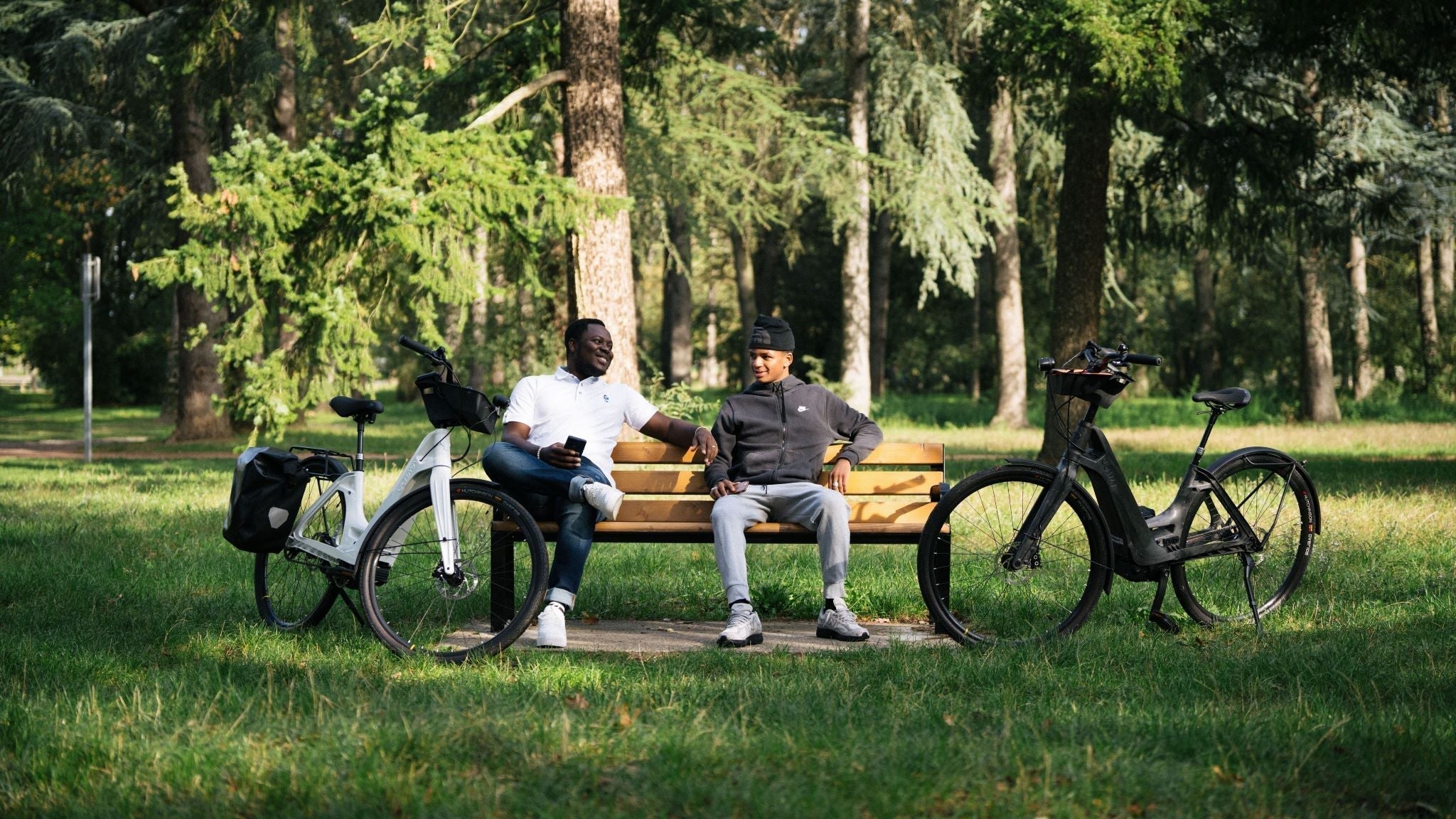 Deux personnes en forêt avec leurs vélos électriques, symbole d'une mobilité plus durable et écologique.