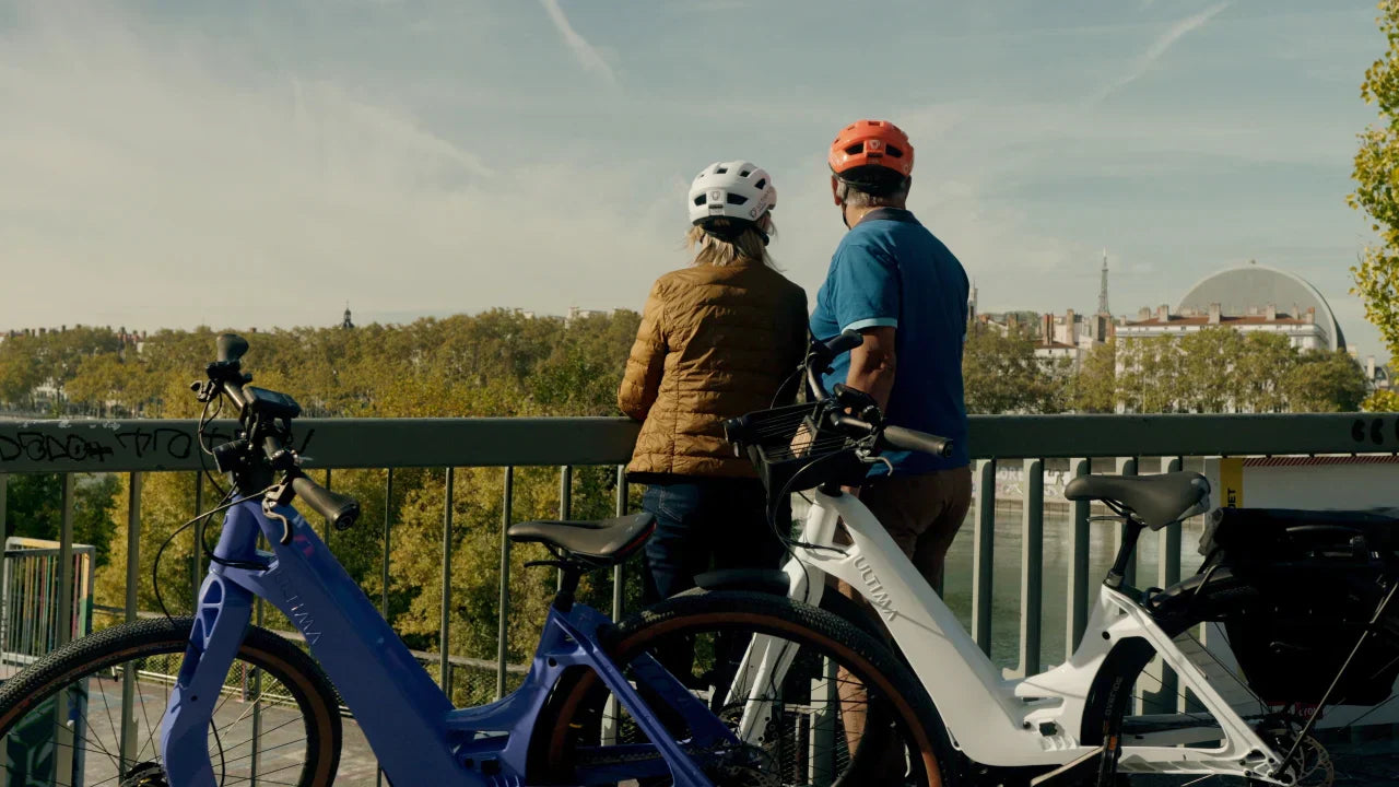 Un homme et une femme équipés de casques avec leur vélos électriques